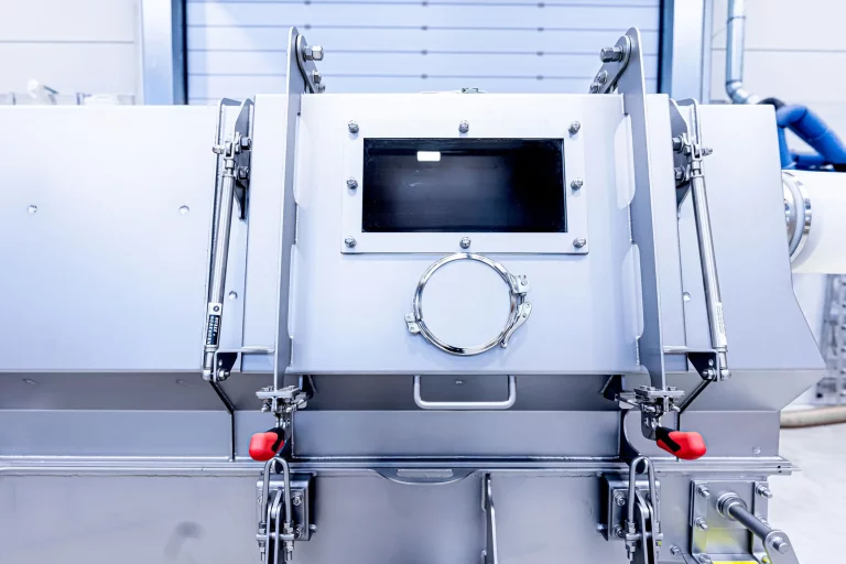 Close-up of an industrial JOEST dryer with inspection window and quick-release fasteners.