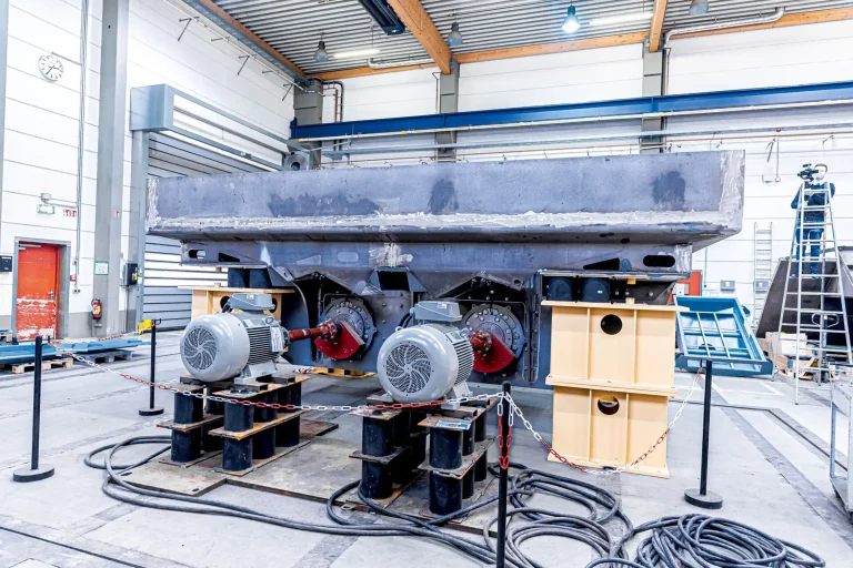 Ausschlagrost mit zwei Elektromotoren in einer Werkhalle, frontal aufgenommen