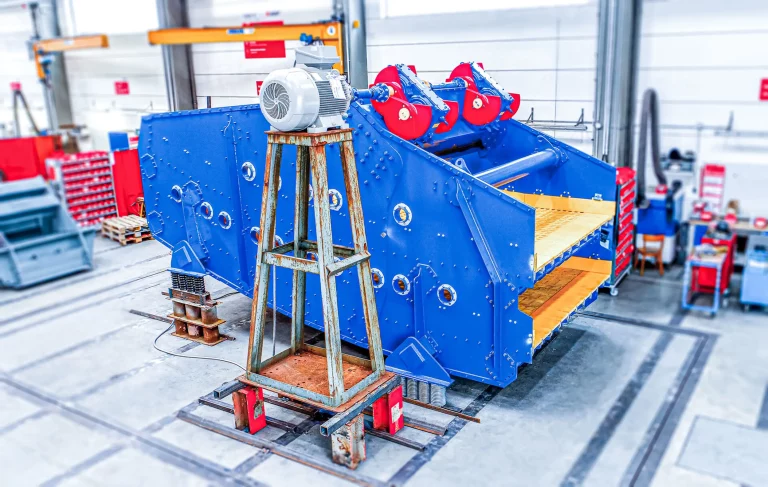 Großes blaues Linearschwingsieb von JOEST für den Einsatz im Bergbau und bei der Aufbereitung von Mineralien, aufgenommen in einer Werkhalle.