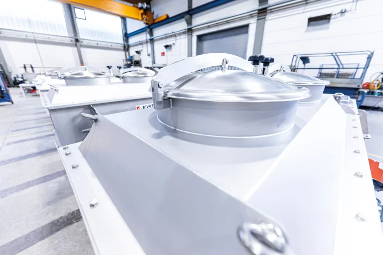 Detailaufnahme eines Linearschwingsiebs für die Lebensmittel- und Chemieindustrie mit Edelstahlabdeckungen und Spannverschlüssen.