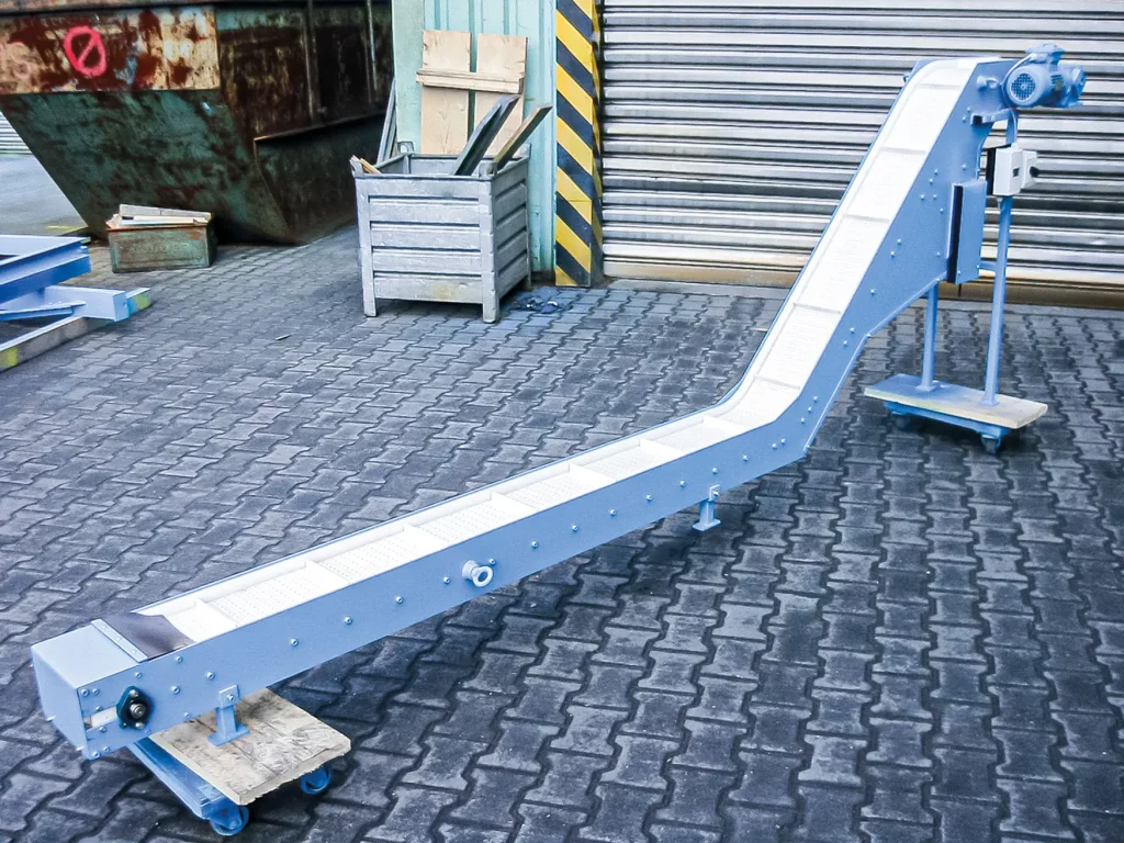 Kunststoff-Scharniergurtförderer in Z-Form für den Transport von Werkstücken in einer Industrieumgebung