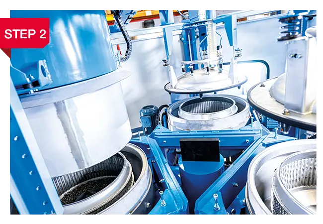 Innenraum einer industriellen Waschzentrifuge mit geöffneten Trommeln und Sprühsystem für heiße Waschlauge.Metallteile mit heißer Waschlauge.