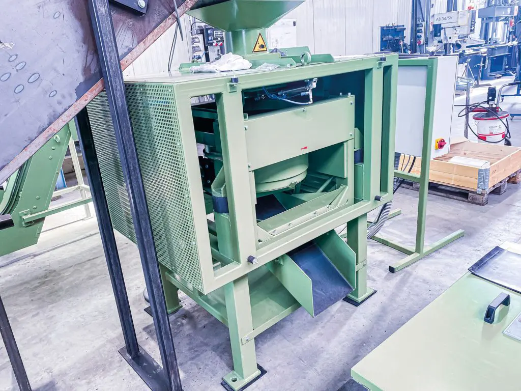 Industrial de-oiling centrifuge for removing oil and lubricants from metal parts in manufacturing.