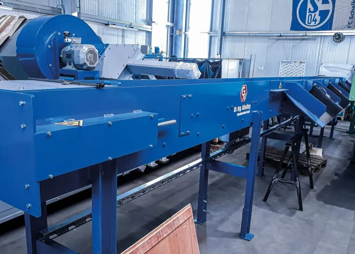 Scharniergurtförderer in einer Industriehalle