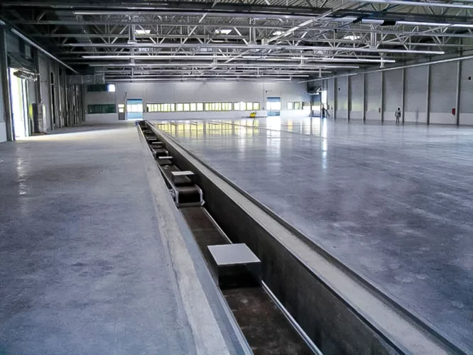 Viele Magnetrutschförderer in H-Ausführung sind im Boden eingebaut und bilden eine lange Kette.