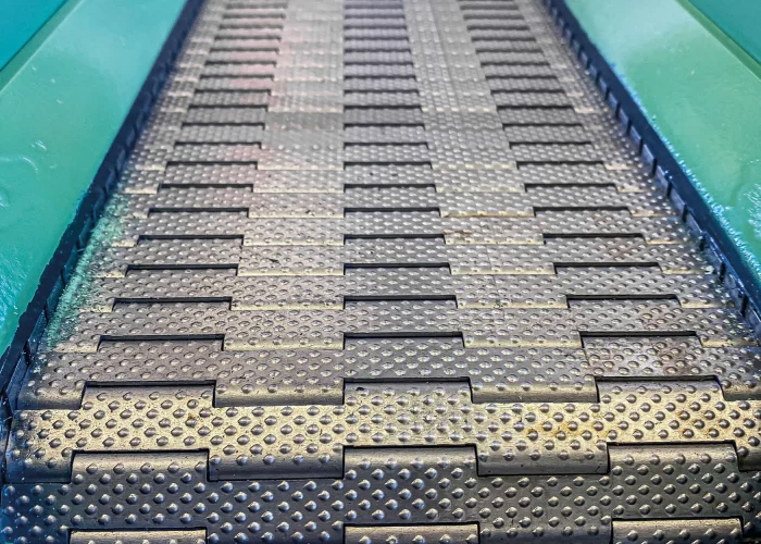 Scharniergurtförderer mit genoppter Stahloberfläche für sicheren Materialtransport in der Industrie