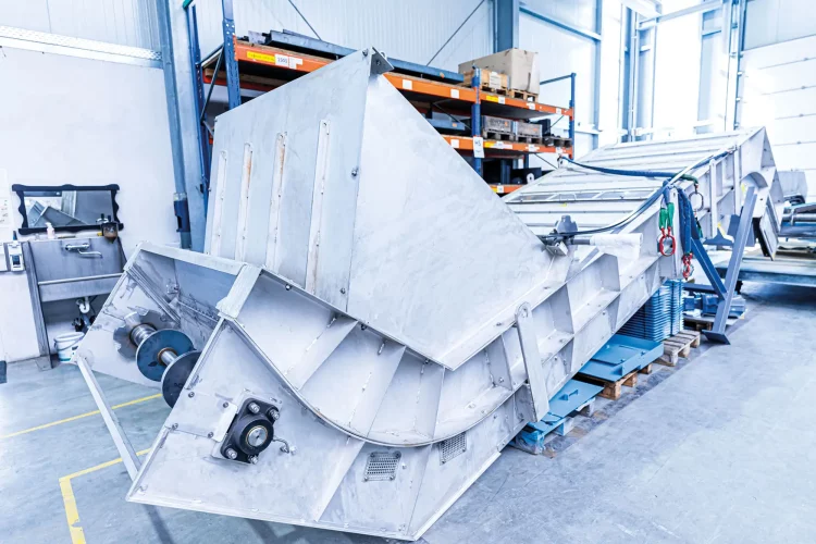 Immersion bath conveyor with robust construction and precise routing in an industrial hall