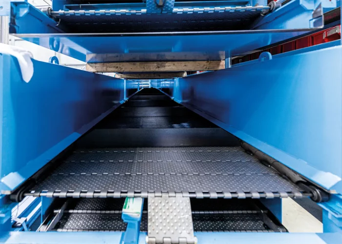 Scharniergurtförderer mit genoppter Oberfläche und PS-Rinnenkante für sicheren Materialtransport