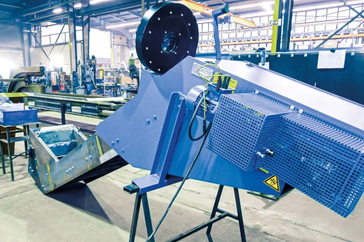 Immersion bath conveyor with compact design and protective cover in a production environment.