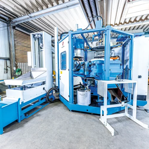 Gesamtansicht einer industriellen Waschzentrifuge mit Austragsbereich zur effizienten Reinigung und Entölung von Metallteilen.