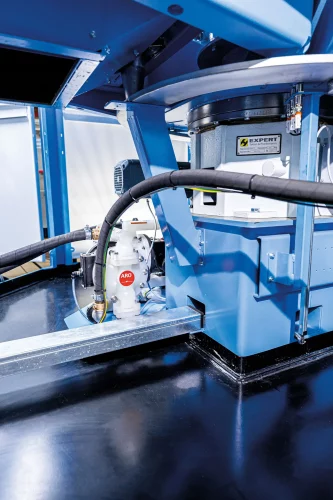 Unterbau einer industriellen Waschzentrifuge mit Antriebseinheit, Pumpe und Schlauchleitungen für den Betrieb in der Metallteilereinigung.