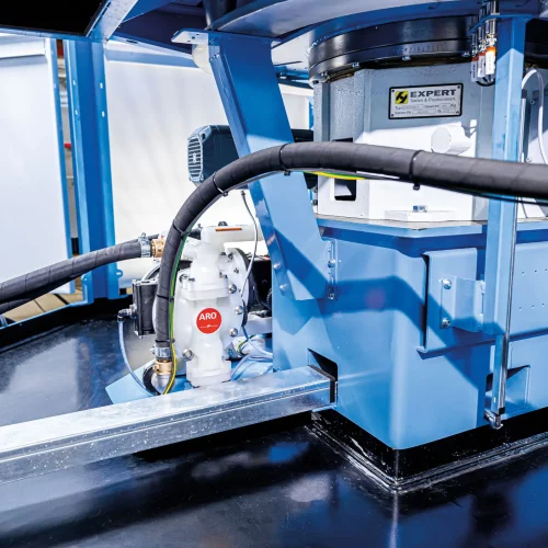 Unterbau einer industriellen Waschzentrifuge mit Antriebseinheit, Pumpe und Schlauchleitungen für den Betrieb in der Metallteilereinigung.