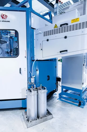 Industrielle Waschzentrifuge mit zwei Edelstahl-Ölbehältern zur Sammlung und Aufbereitung abgeschleuderten Öls bei der Reinigung von Metallteilen.