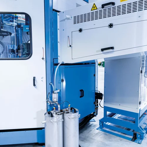 Industrielle Waschzentrifuge mit zwei Edelstahl-Ölbehältern zur Sammlung und Aufbereitung abgeschleuderten Öls bei der Reinigung von Metallteilen.