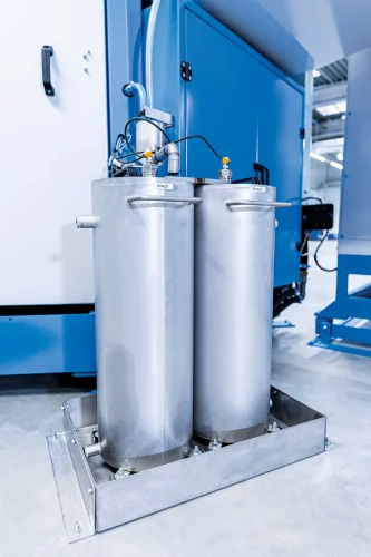 Dual-chamber stainless steel container on an industrial washing centrifuge for separating rolling oil and pressing oil.