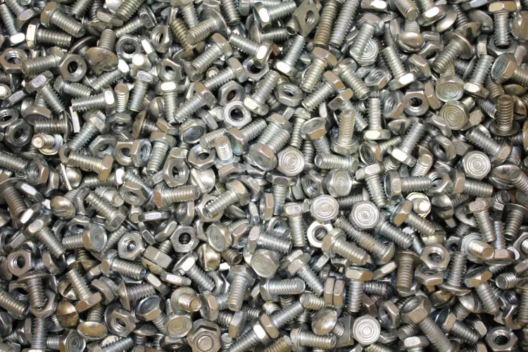 Large number of cleaned small screws and nuts after being cleaned in the washing centrifuge.
